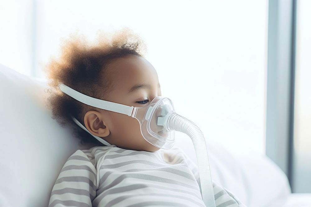 African baby boy use nebulizer mask relaxation innocence furniture. AI generated Image by rawpixel.