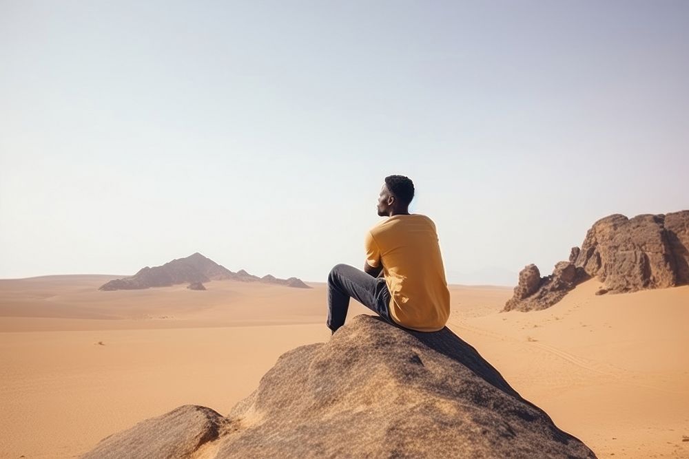African american man sitting desert outdoors. AI generated Image by rawpixel.