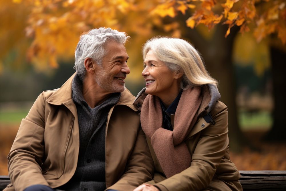 Middle-aged couple laughing sitting autumn. AI generated Image by rawpixel.