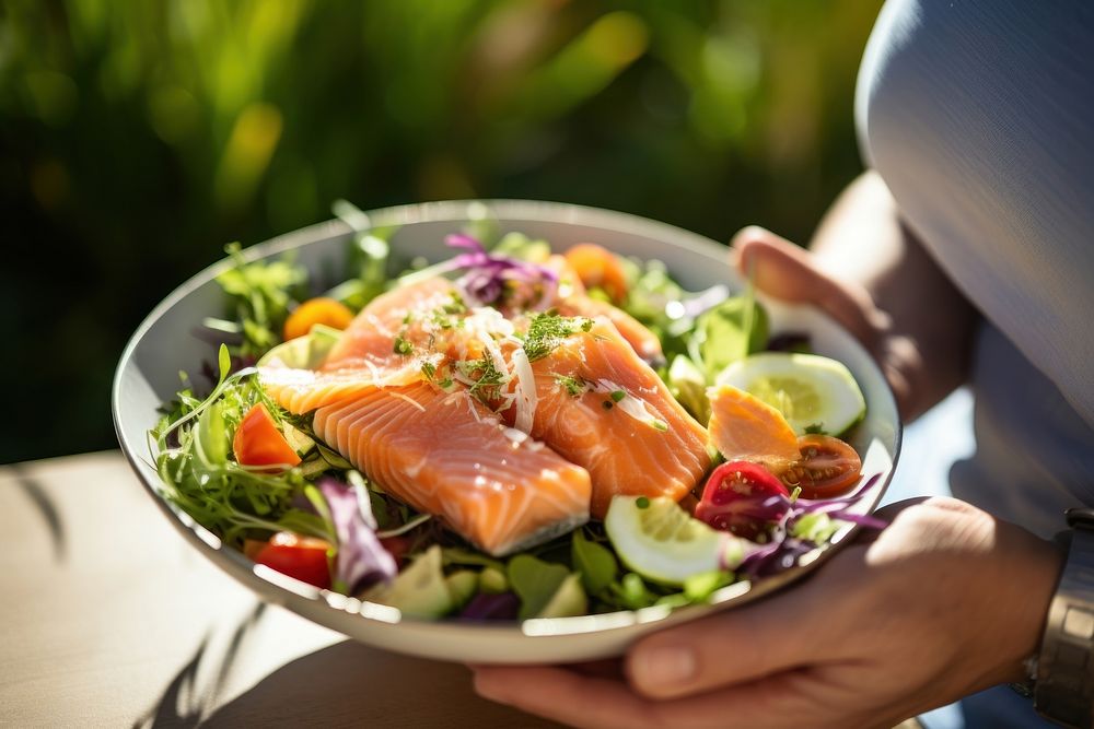 Salmon salad seafood plate hand. AI generated Image by rawpixel.