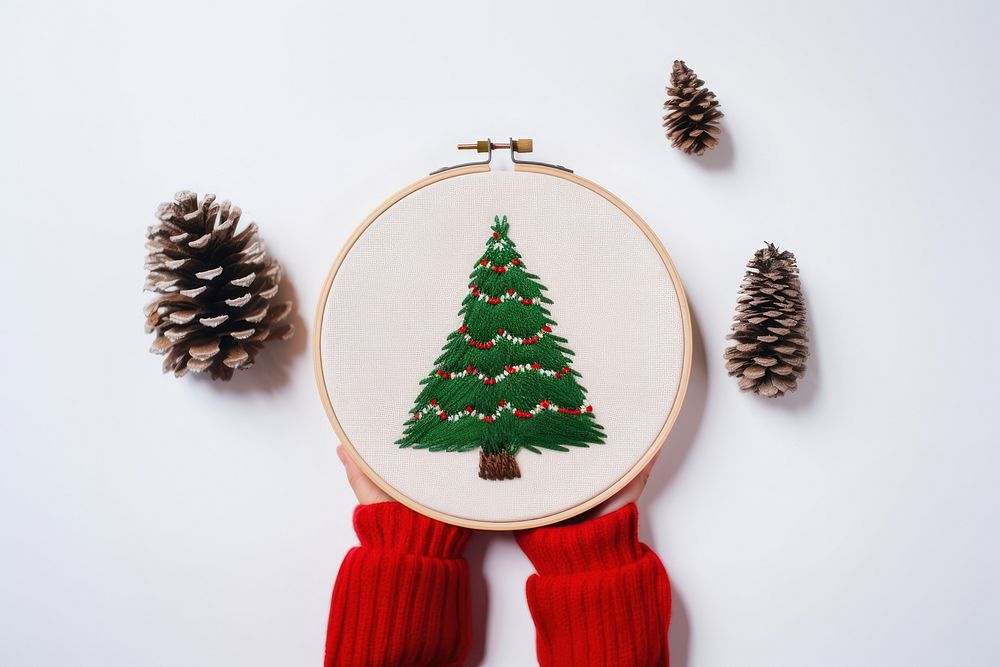 A hand holding Christmas tree embroidery christmas pattern christmas tree. AI generated Image by rawpixel.