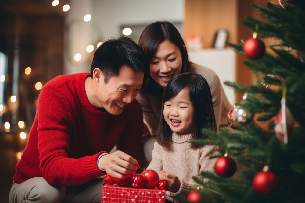 Asian family decorating christmas tree holiday adult togetherness. AI generated Image by rawpixel.