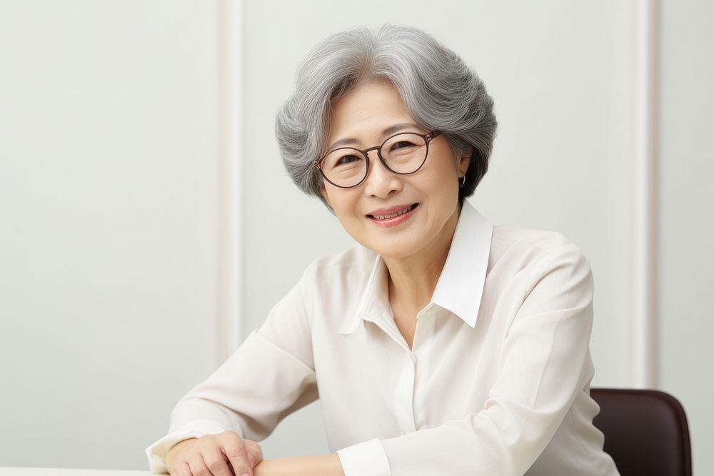 Smiling senior korea business woman glasses portrait sitting. AI generated Image by rawpixel.