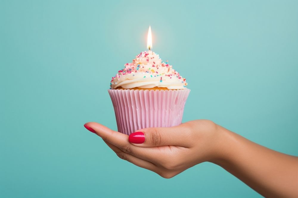 Hand holding cupcake candle birthday dessert. AI generated Image by rawpixel.