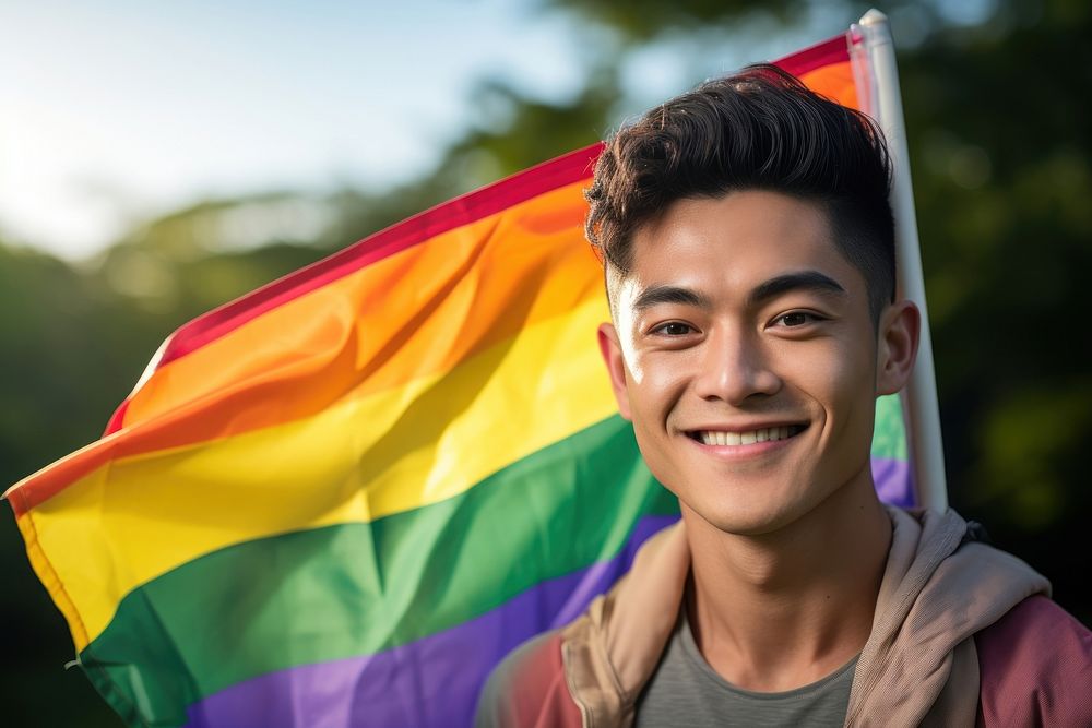 Thai gay man holding rainbow pride. AI generated Image by rawpixel.