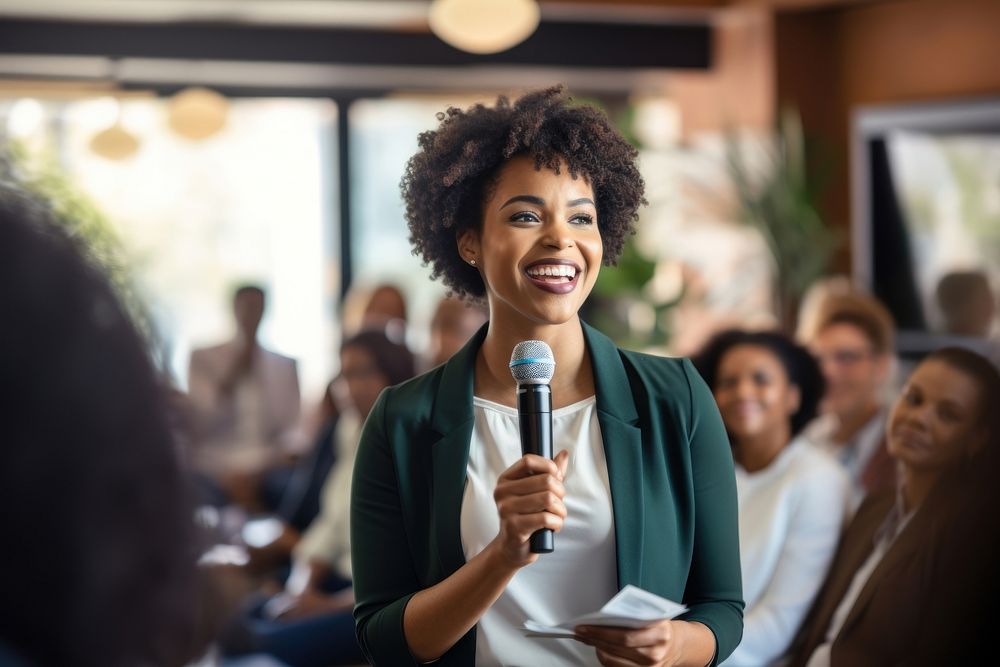 African american woman microphone audience smiling. AI generated Image by rawpixel.