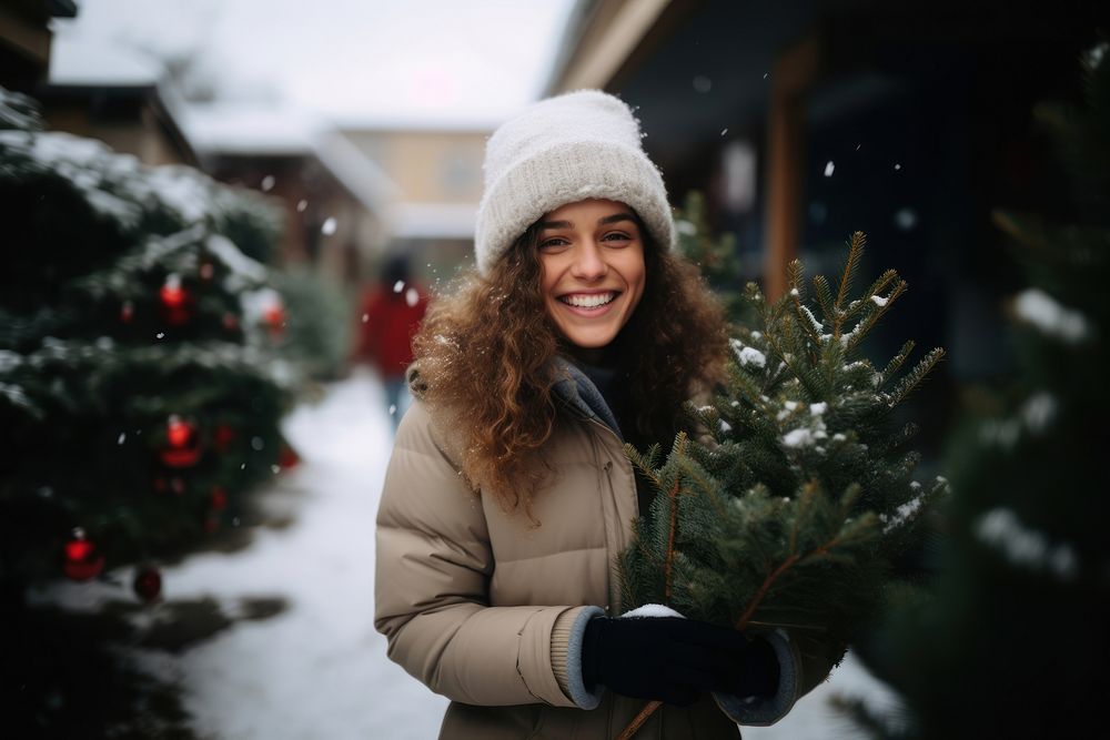 Happy woman carrying small christmas tree snow outdoors nature. AI generated Image by rawpixel.