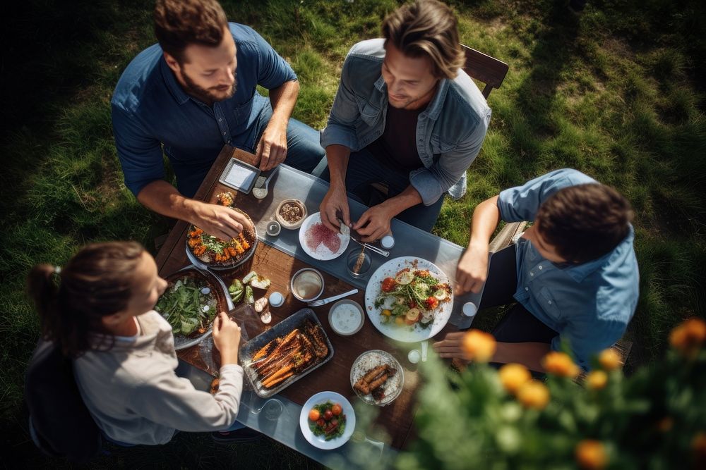 Family having food outdoors plate adult. AI generated Image by rawpixel.