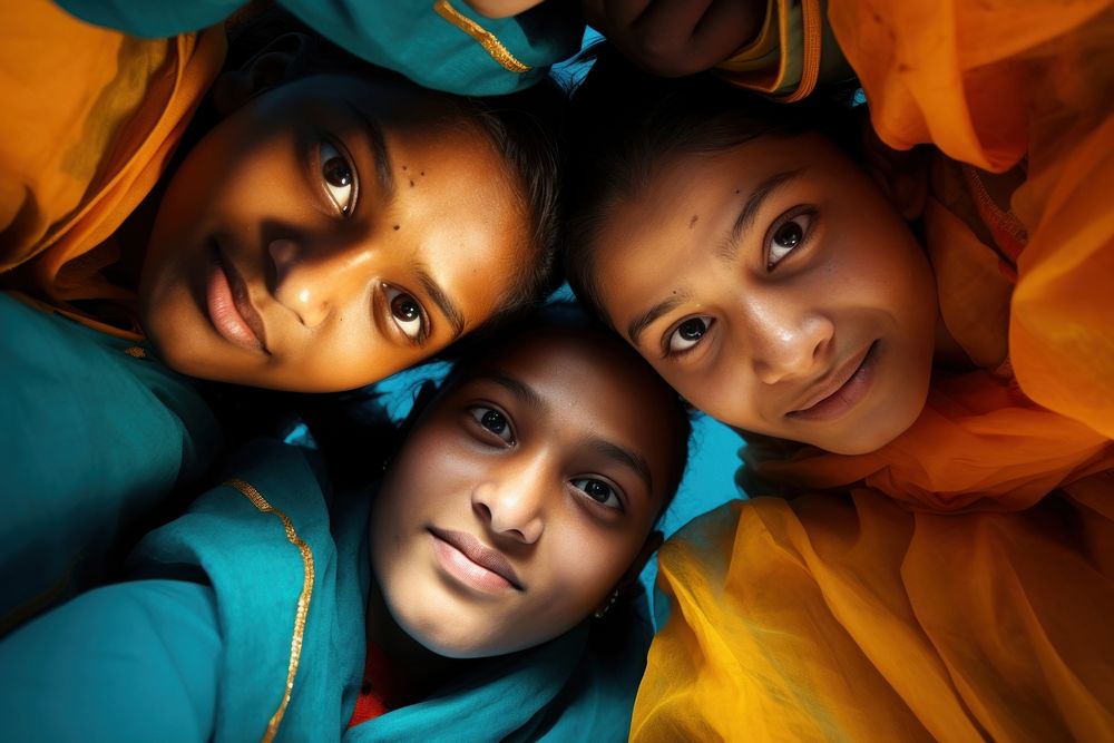 Four indians valunteer forming huddle portrait head togetherness. AI generated Image by rawpixel.