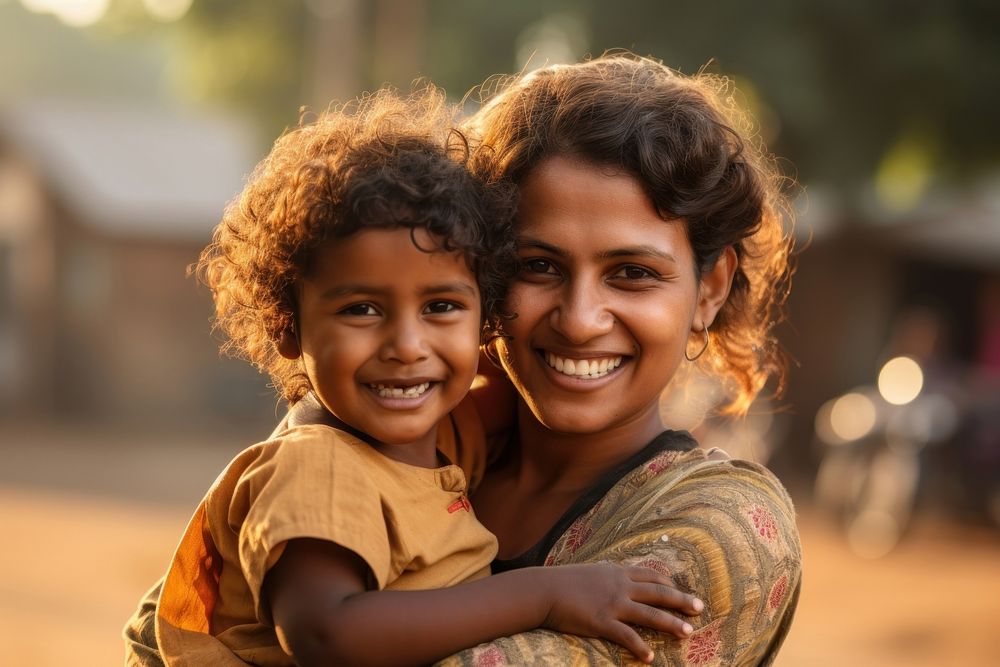 Woman Indian volunteer holds a Indian child on arms smile happy togetherness. AI generated Image by rawpixel.