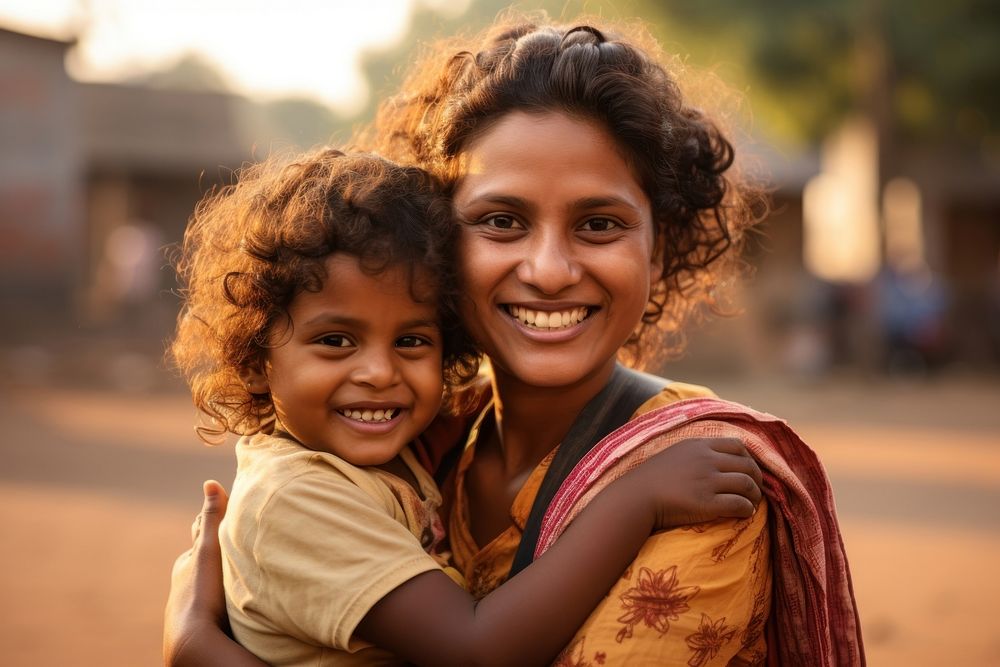 Woman Indian volunteer holds a Indian child on arms smile happy togetherness. AI generated Image by rawpixel.