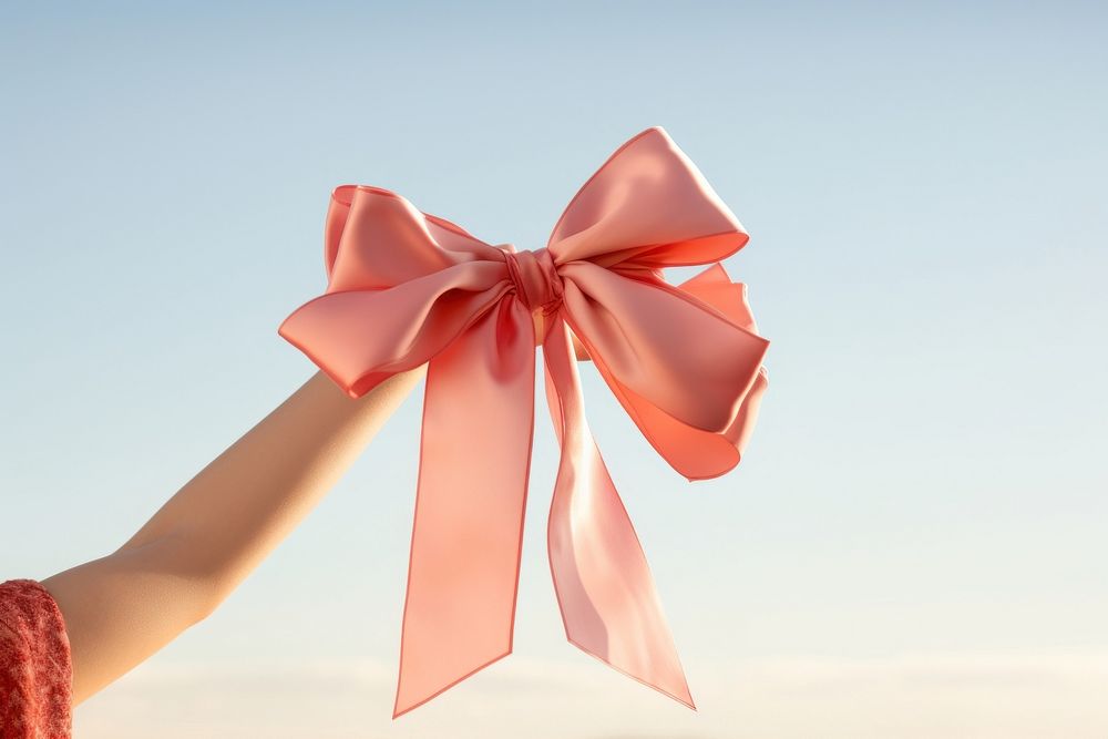 Hand holding big bow celebration anniversary accessories. AI generated Image by rawpixel.