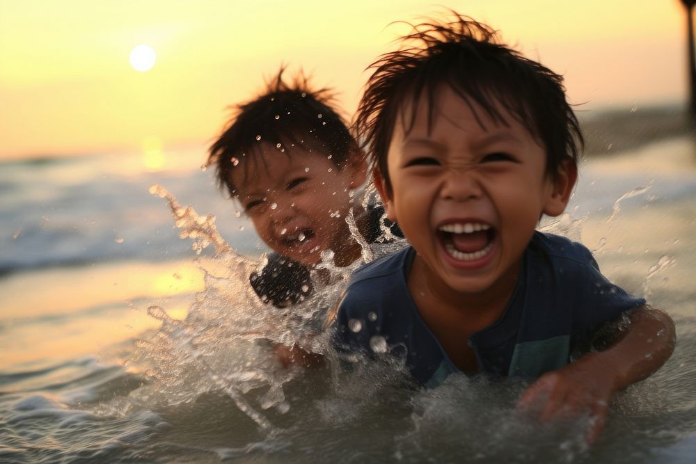East asian boy splash water to his brother beach swimming laughing. AI generated Image by rawpixel.