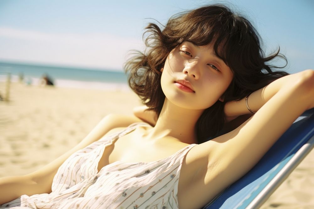 Korea girl lying in the sun on the beach photography sunbathing portrait. AI generated Image by rawpixel.