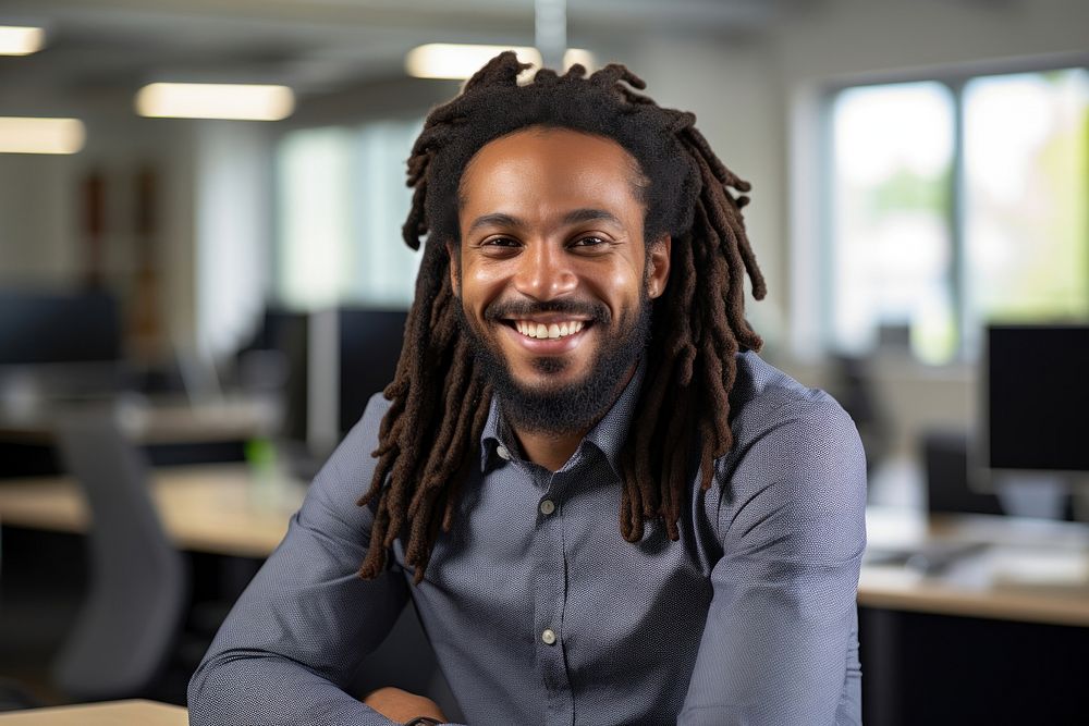 African man with dreadlocks smiling at the camera during a meeting in a business office adult smile businesswear. AI…