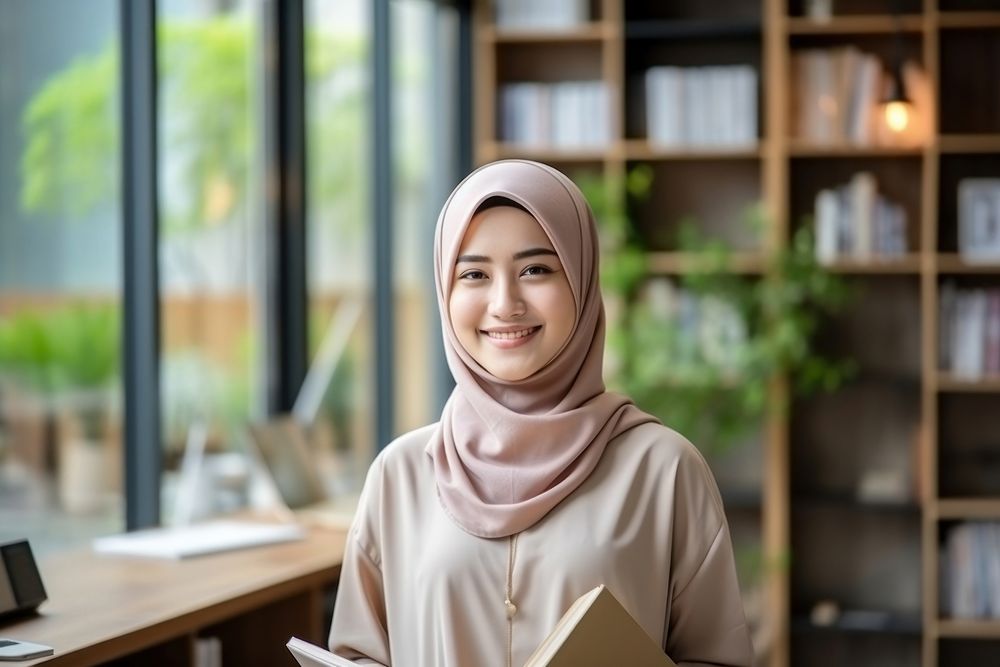 A smile student muslim woman holding book portrait entrepreneur technology. AI generated Image by rawpixel.