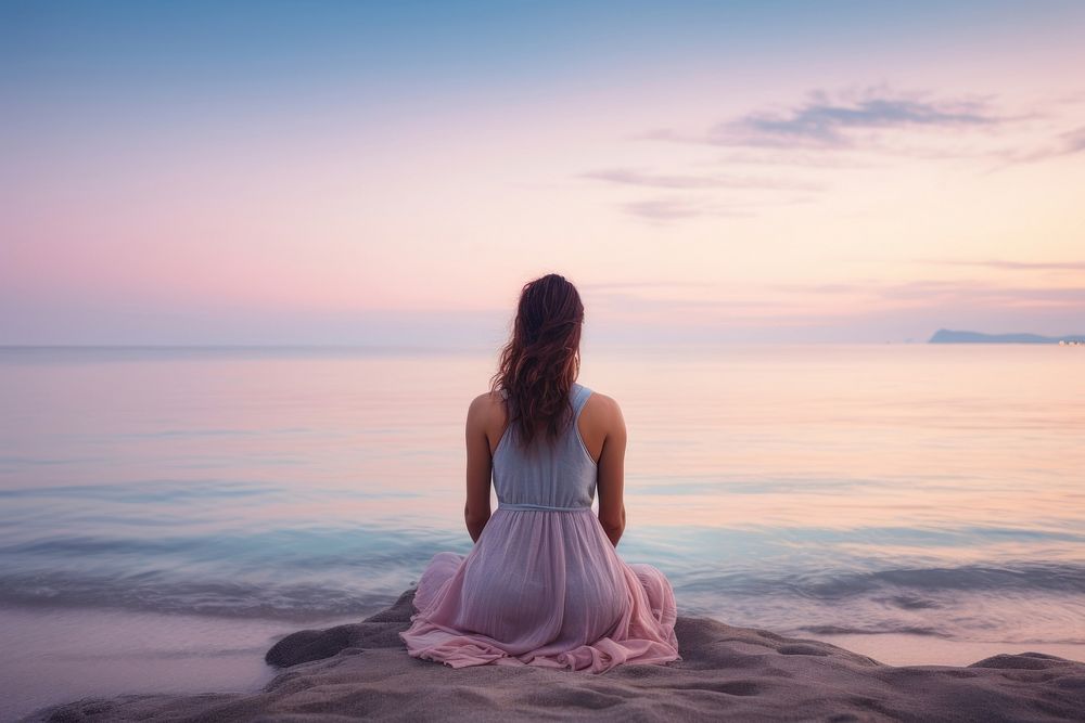 Woman meditating on the beach sea sky outdoors. 