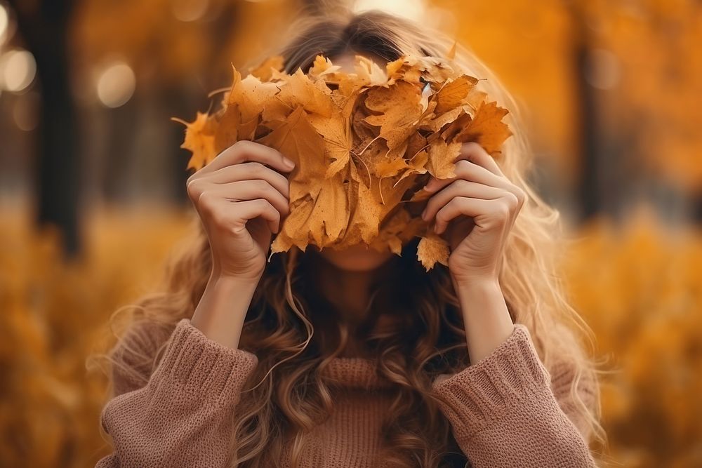Woman with big one autumn leave cover her face in autumn park plant leaf celebration. AI generated Image by rawpixel.