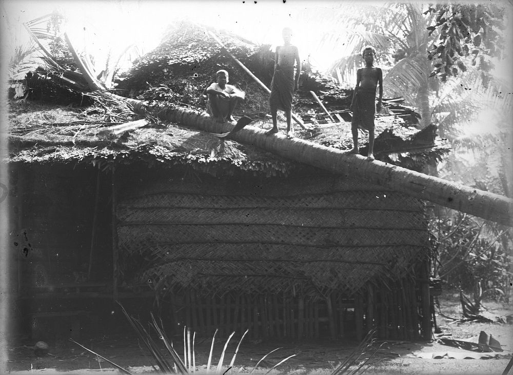 Boys at a damaged building (1880-1925).