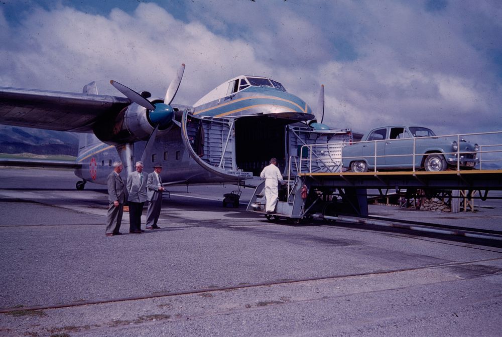 Loading car on to New Zealand Rlys (Railways) Airlift Freighter plane (24 March 1959) by Leslie Adkin.