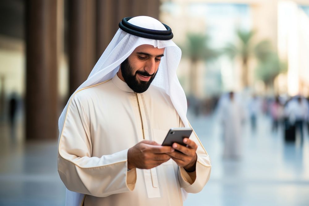 Arab man using mobile phone city architecture portability. AI generated Image by rawpixel.