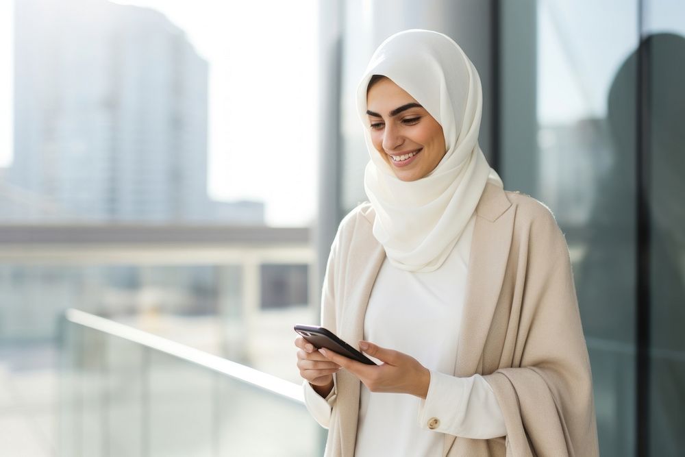 Arab woman using mobile phone scarf adult city. AI generated Image by rawpixel.