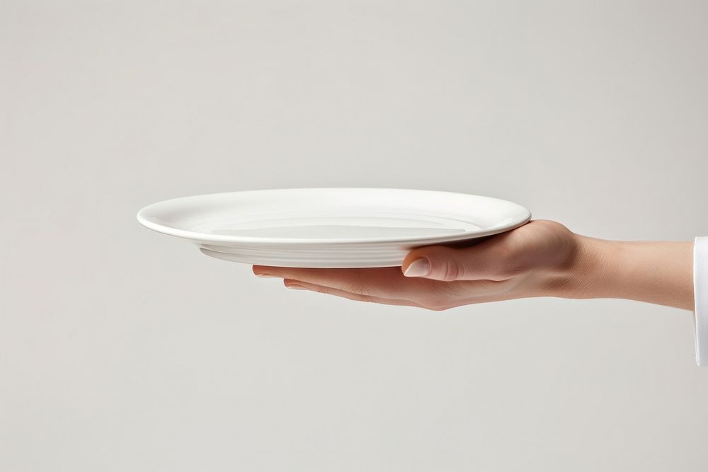 A man waitress hand is holding up a platter porcelain plate white. AI generated Image by rawpixel.