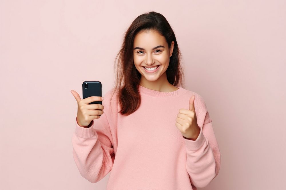 Woman holds mobile phone in hand selfie smile adult. AI generated Image by rawpixel.