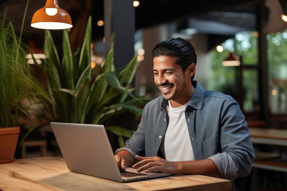 Mexican man working on laptop computer smiling adult. AI generated Image by rawpixel.