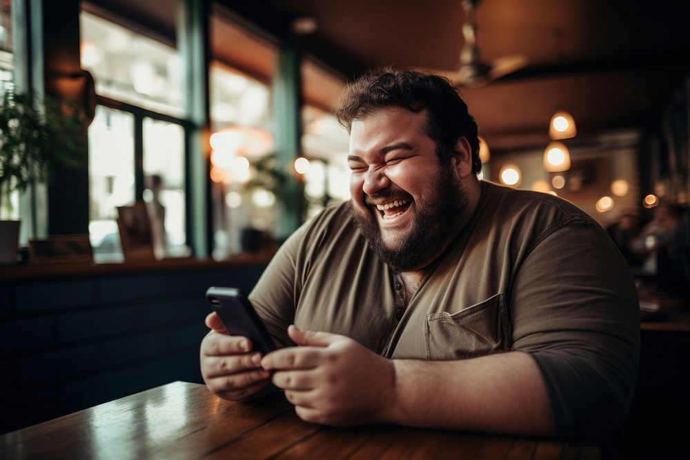 Happy relaxed chubby man using cell phone laughing sitting smiling. AI generated Image by rawpixel.