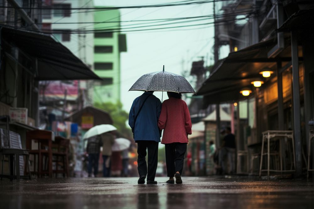 Thai people standing under an clear umbrella in the rain walking street adult. AI generated Image by rawpixel.