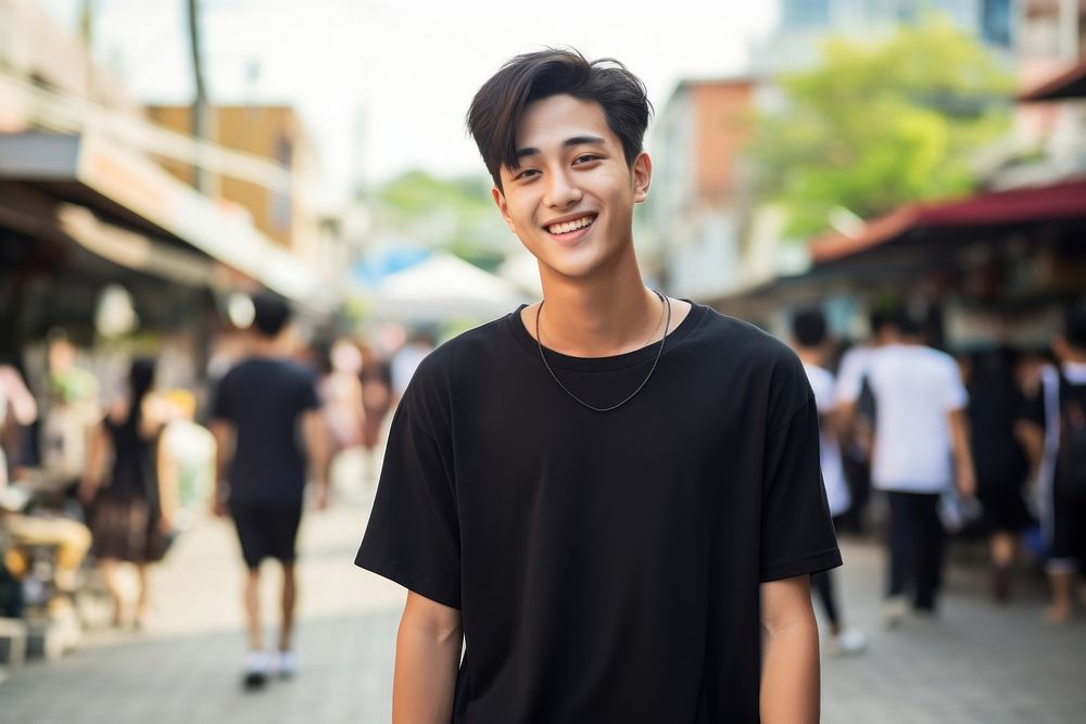 Thai teenager wearing black t-shirt walking at the urban street adult smile individuality. AI generated Image by rawpixel.