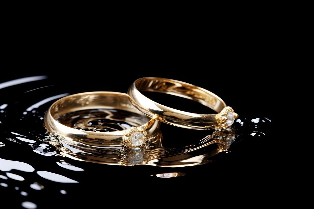Two Golden Wedding Rings Sinking in Water ring jewelry diamond. AI generated Image by rawpixel.