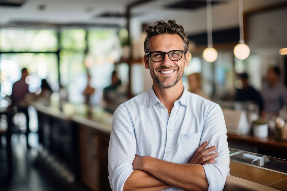 Man smiling at the counter working glasses adult. AI generated Image by rawpixel.