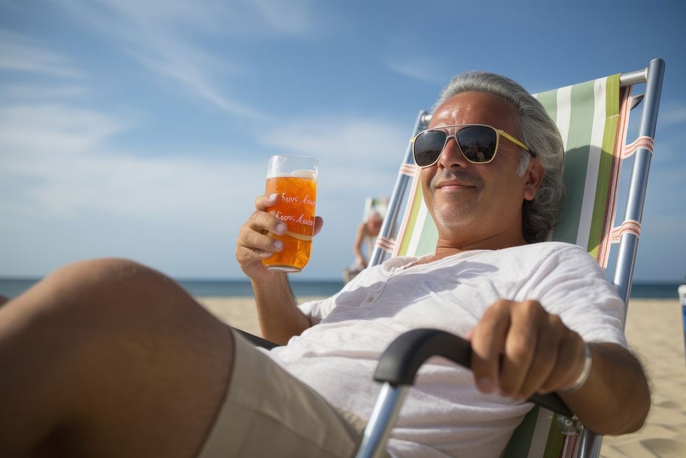 Male latinx in holding soda can while sitting on beach chair photography sunbathing sunglasses. AI generated Image by…