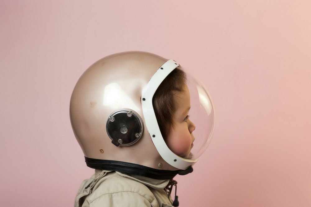 Child wearing astronaut helmet protection headgear headwear. AI generated Image by rawpixel.