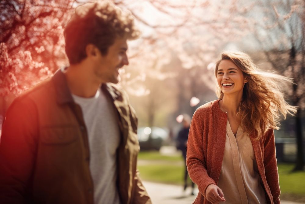 A young couple walking together in the park laughing adult smile. AI generated Image by rawpixel.