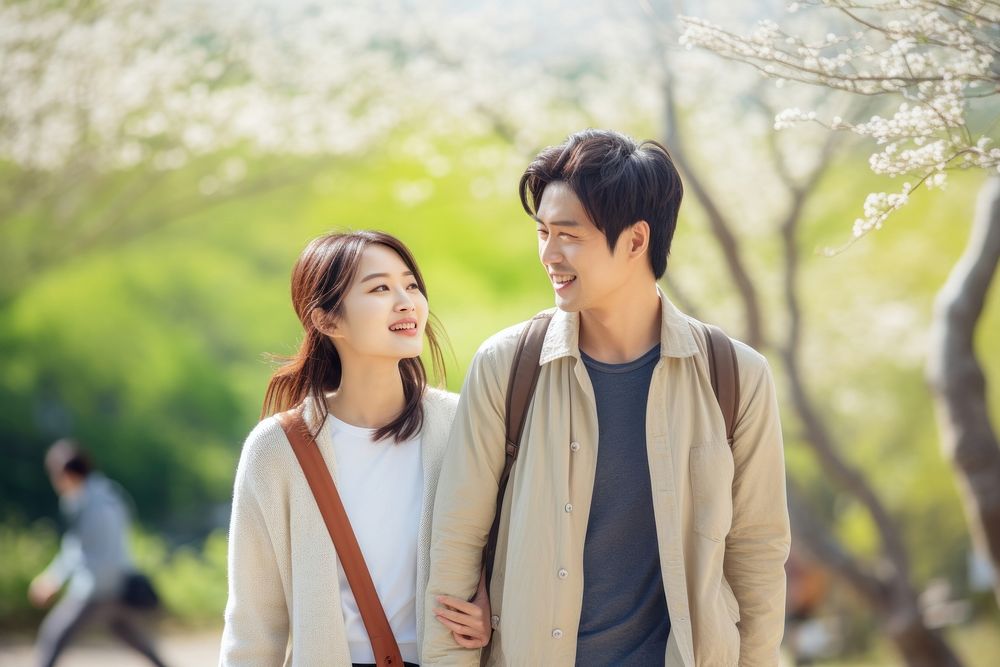 A young couple walking together in the park adult smile day. AI generated Image by rawpixel.