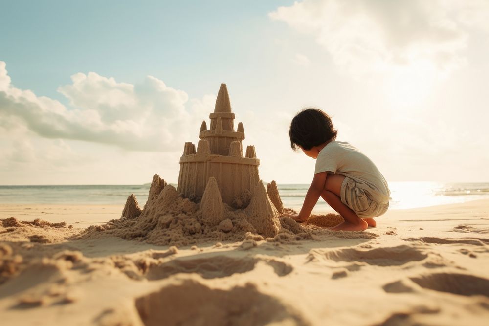 East Asian kid building sand castle outdoors summer nature. AI generated Image by rawpixel.