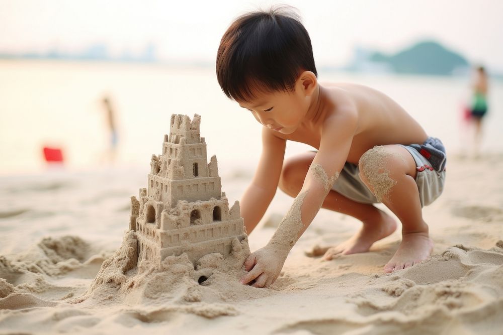 East Asian kid building sand castle outdoors summer beach. AI generated Image by rawpixel.