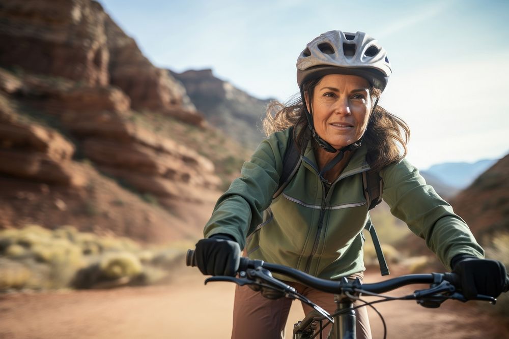 Mature woman riding bike on mountain trail cycling bicycle vehicle. 