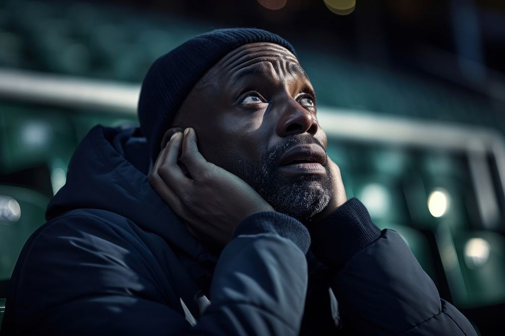 Black mature man sad at football game in stadium sports adult contemplation. AI generated Image by rawpixel.