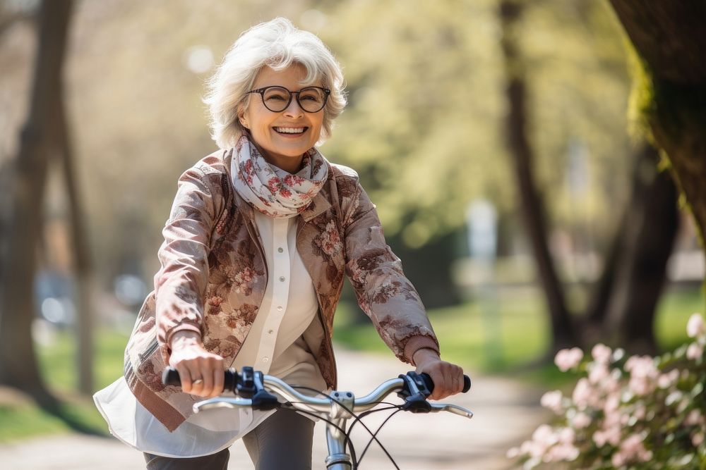 Middle age woman riding bicycle bike cycling outdoors glasses. AI generated Image by rawpixel.