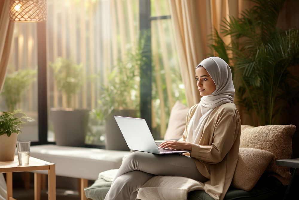 Young hijab female tech relaxing computer laptop sitting. AI generated Image by rawpixel.