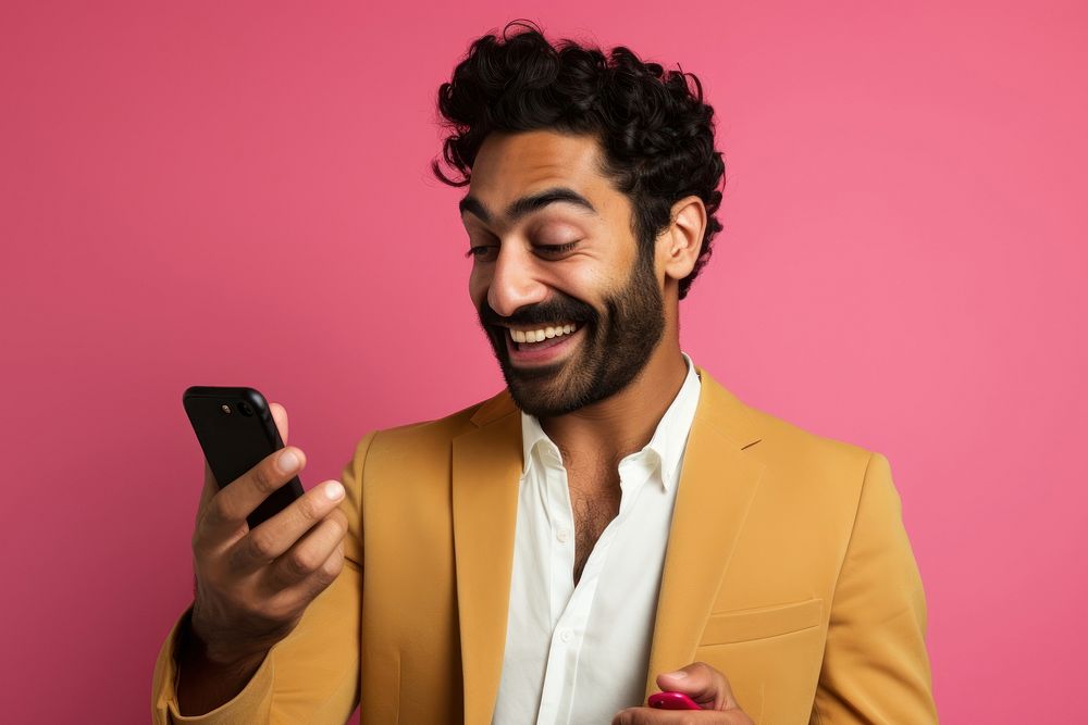 An 27 yo indian pointing at his phone happiness laughing adult. AI generated Image by rawpixel.