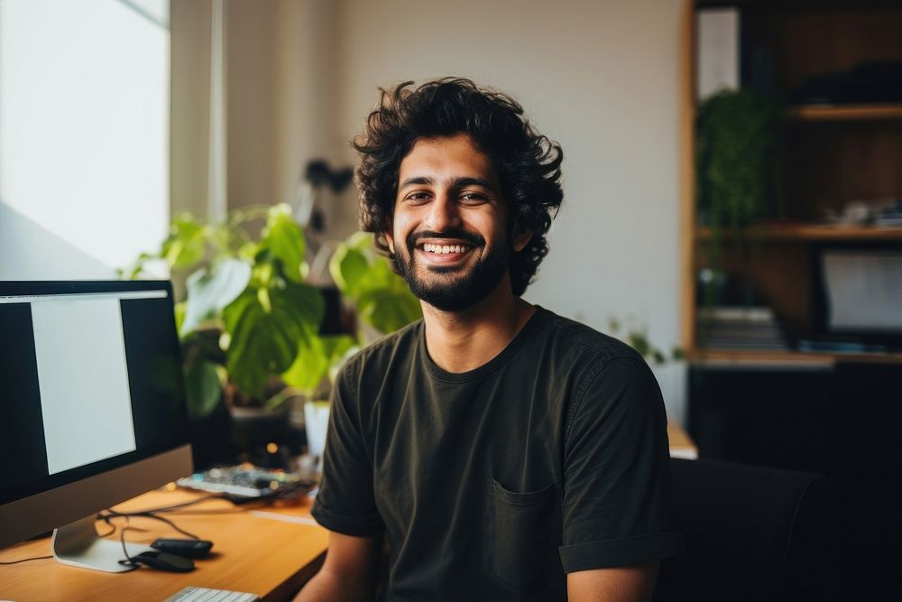 A happy 27 yo Graphic Designer from india working in minimal office computer adult smile. AI generated Image by rawpixel.