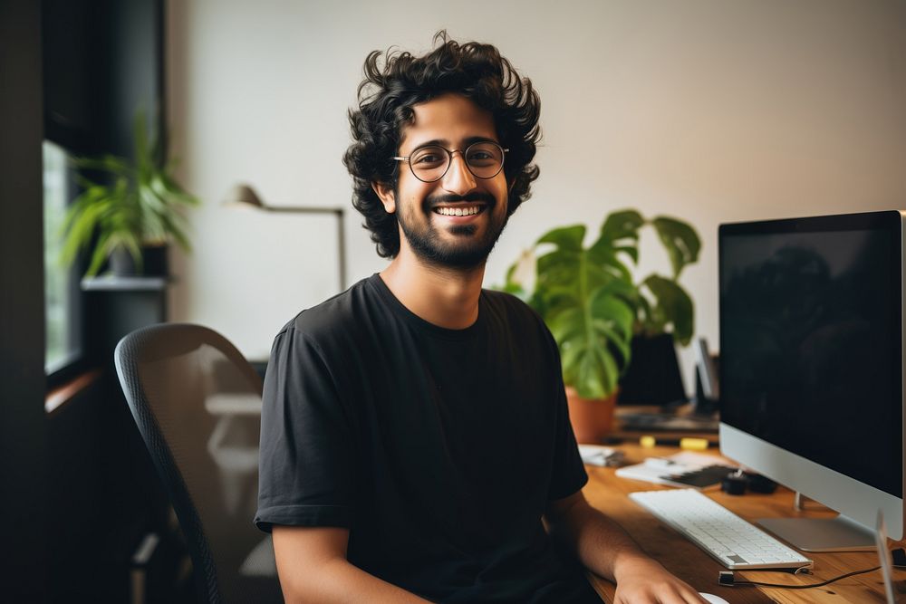 A happy 27 yo Graphic Designer from india working in minimal office computer glasses smile. AI generated Image by rawpixel.