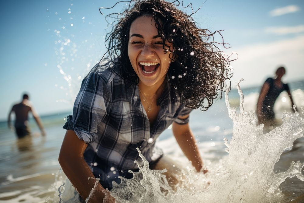 Woman playing water at a beach smile laughing outdoors. AI generated Image by rawpixel.