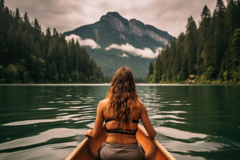 Women rowing a kayak lake mountain outdoors. AI generated Image by rawpixel.