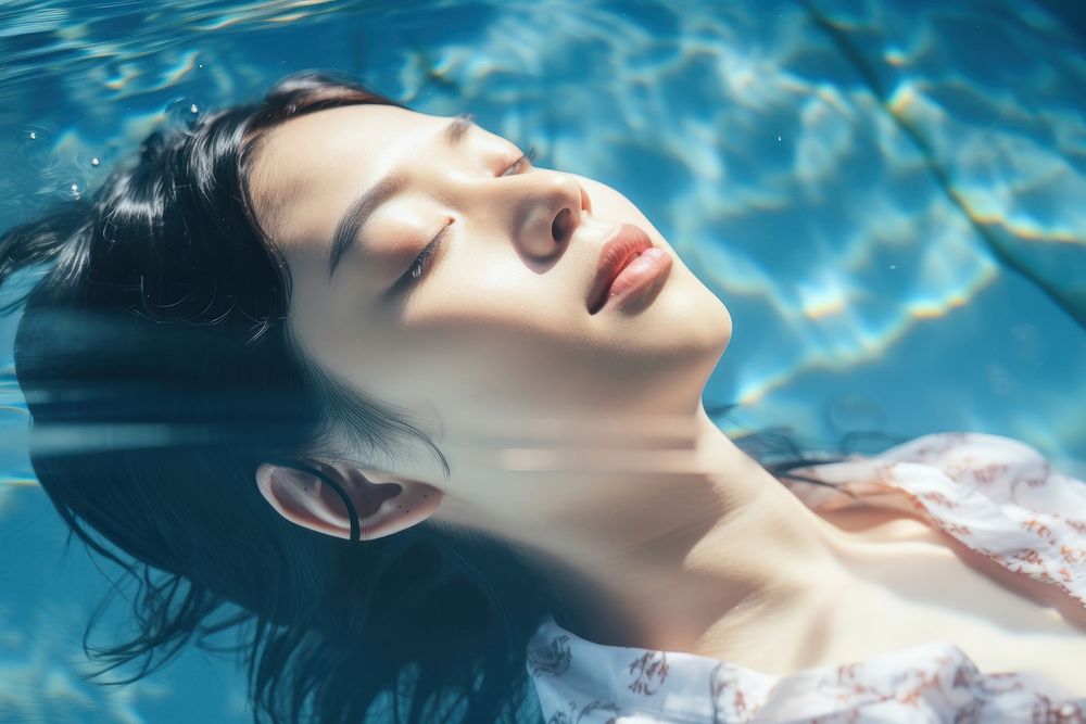Asian woman laying in a swimming pool reflection portrait summer. AI generated Image by rawpixel.